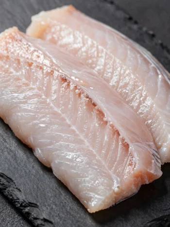Fresh eel fillets with spices on a wooden cutting board